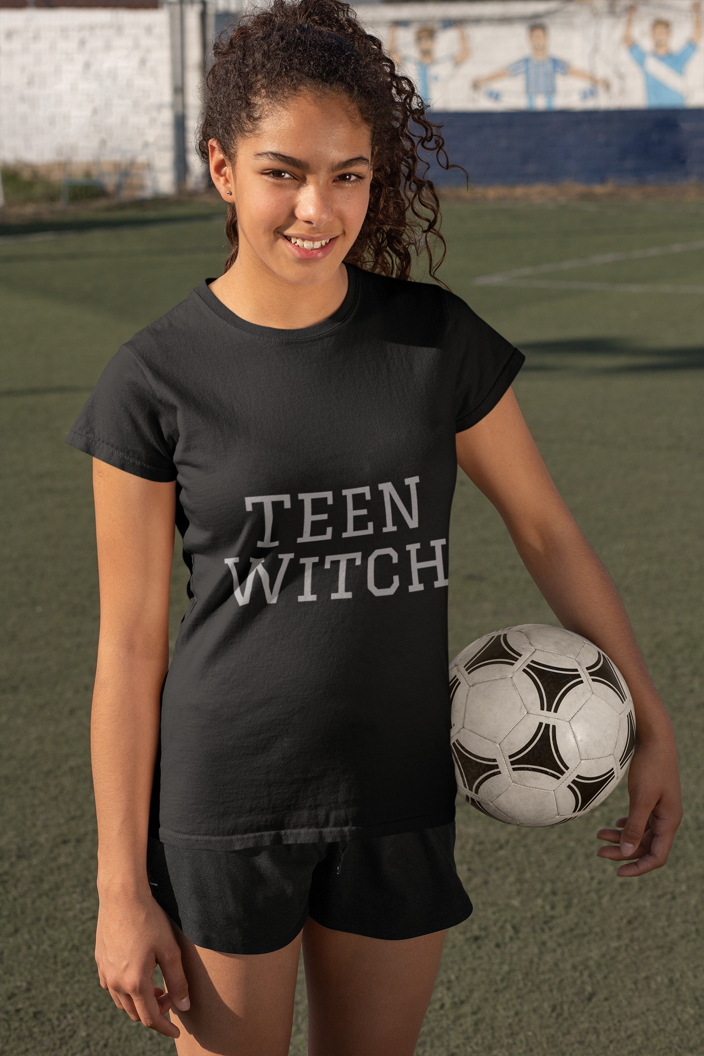 Teen Witch Unisex Jersey Short Sleeve Tee Teen Witch black unisex jersey short sleeve tee worn by teen holding soccer ball on field