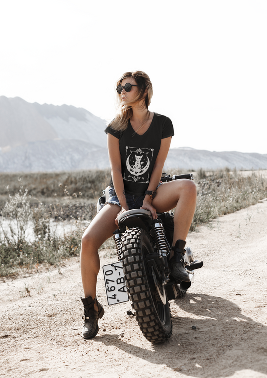 Mystical Moon Cat V-Neck T-Shirt worn by woman sitting on motorcycle in outdoor setting.