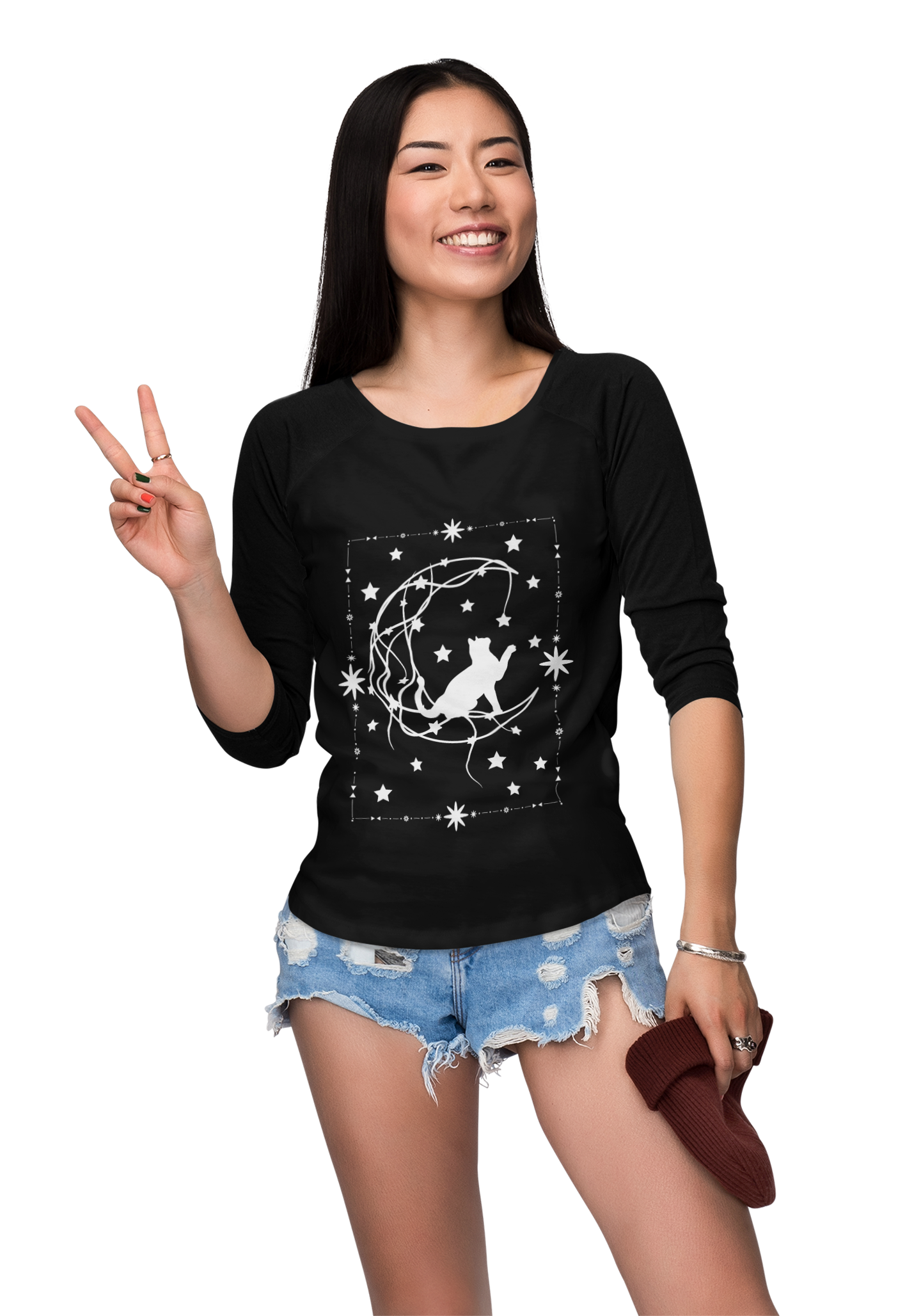 Woman wearing black Celestial Cat Unisex T-shirt with white starry night cat design and ripped denim shorts, smiling and making peace sign.