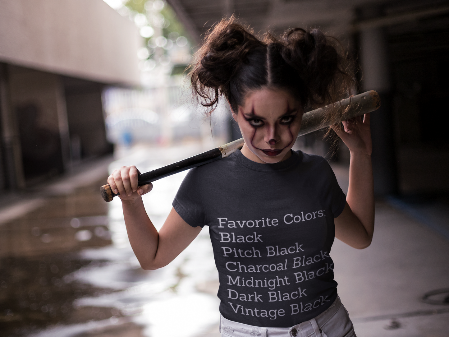 Unisex black cotton T-shirt with goth-style text listing favorite black shades, worn by person with dark makeup holding a baseball bat.