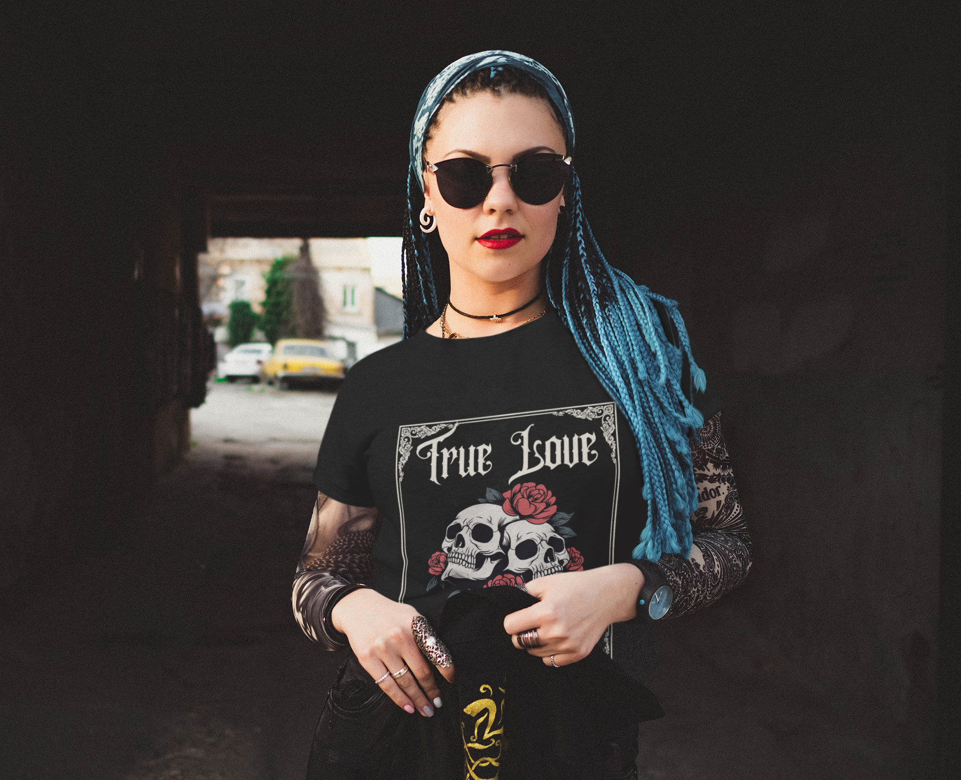 Woman wearing black "Till Death Tee" featuring two skulls with red roses and Victorian border design