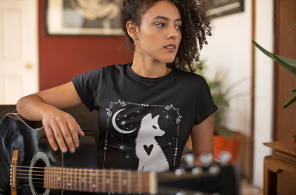 Woman wearing black Celestial Fox Tee with white fox silhouette and night sky design playing guitar indoors