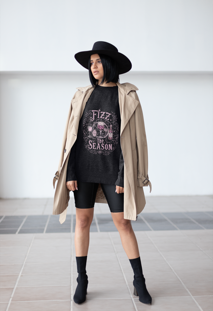 Woman wearing Fizz the Season champagne holiday sweatshirt with trench coat and black hat in an urban setting