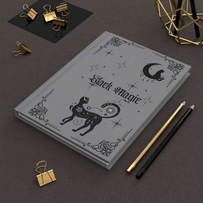 Black Magic Journal with black cats, glowing moon, and stars on matte black cover