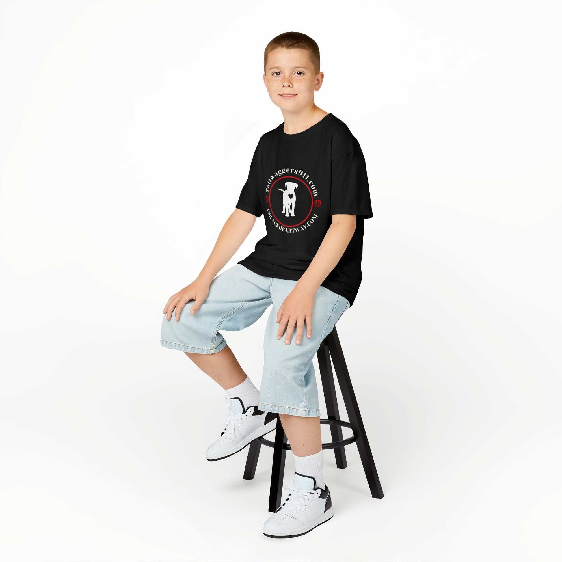 Child wearing Tailwaggers 911 Kids Heavy Cotton Tee black dog rescue shirt sitting on stool